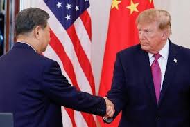 米中首脳会談で握手するトランプ大統領と習近平国家主席(アメリカと中国の国旗の前で)