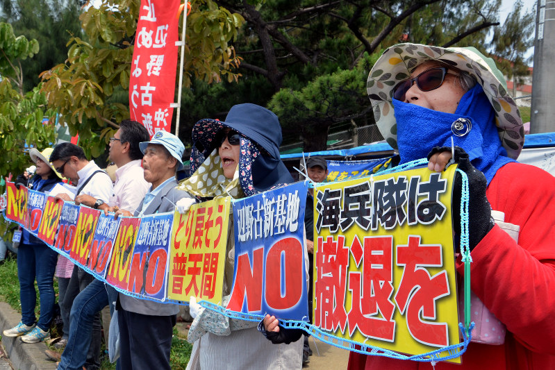 「辺野古新基地NO」「海兵隊は撤退を」のプラカードを掲げて抗議する辺野古の基地反対派活動家たち