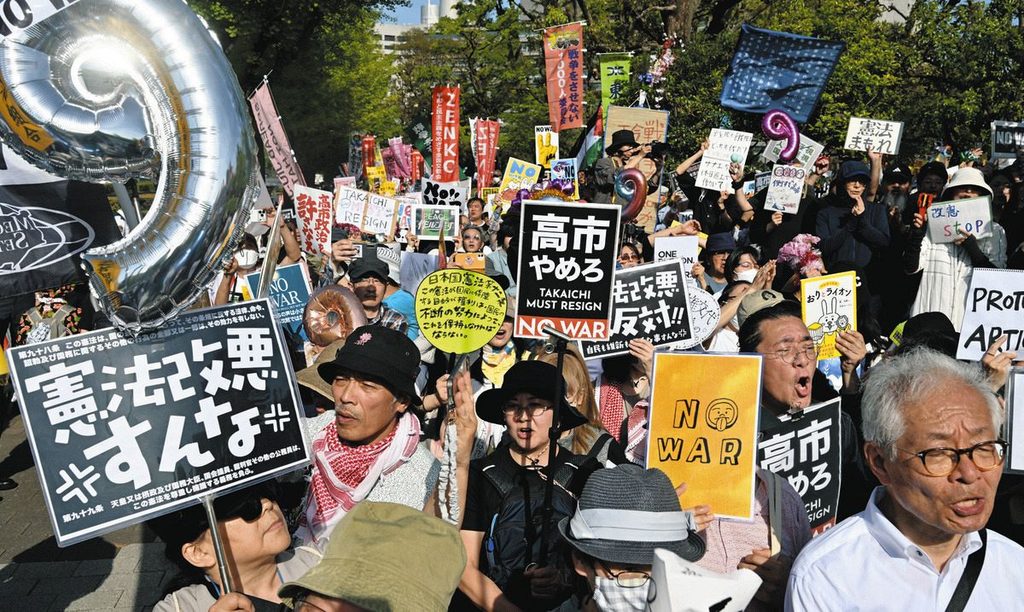 「高市やめろ」のプラカードが並ぶ国会前デモ。総がかり行動を構成する団体ののぼりも写っている。